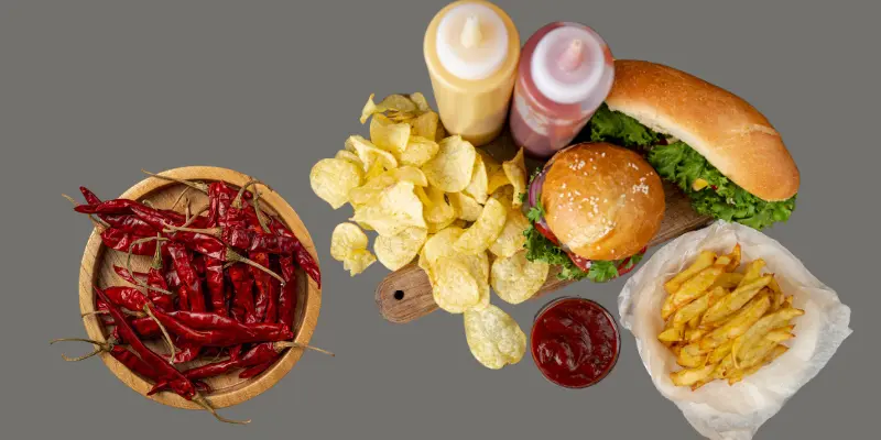 Different Types Of Oily Greasy Fast Foods Including Burgers Chips Catchups Are Placed With A Plate Of Chillies Different types of oily greasy fast foods including burgers chips catchups are placed with a plate of chillies